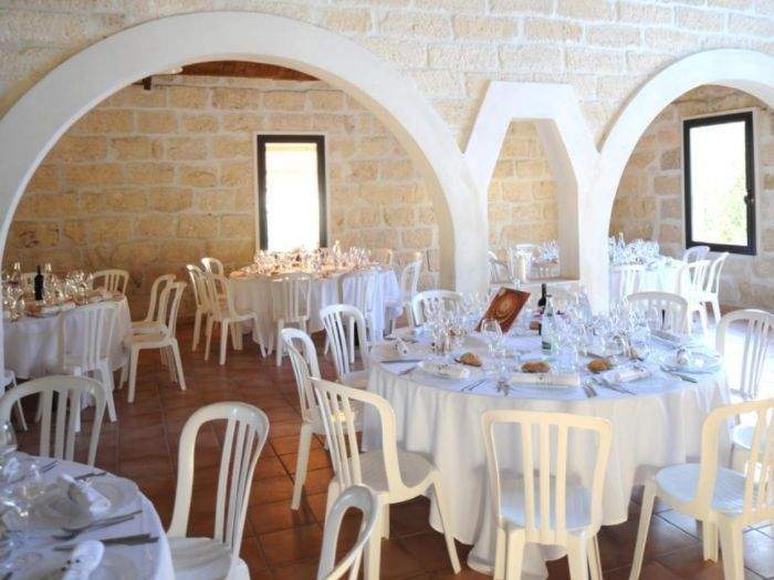 Salle de réception de mariage, aménagée avec des tables et des chaises blanches Marsillargues